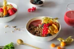 Beerenbowl Frühstücksbowl: Granola in einer Schale mit frischen Beeren als Topping