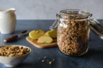 Selbst gemachtes Granola zuckerfrei – im Glas abgefüllt und in der Müslischale mit geschnittenen Äpfeln