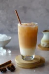 Iced Chai Latte im Glas mit Crushed Ice und Ahornsirup