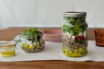 Quinoa Salat im Glas, zwei verschieden große Einmachgläser für unterwegs, der Salat in Schichten eingefüllt