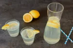 Getränk ohne Zucker: Soda Zitron in einer Karaffe und zwei Gläsern, mit Zitronenscheiben garniert
