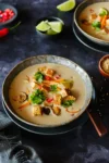 Tom Kha Gai vegan in einer Bowl, garniert mit Chili, Limette und Sesam