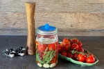 Fermentierte Tomaten: Zutaten und Tomaten im Fermentierglas, mit Krautstampfer