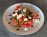 Wassermelonen-Feta-Salat mit Rucola auf einem Teller